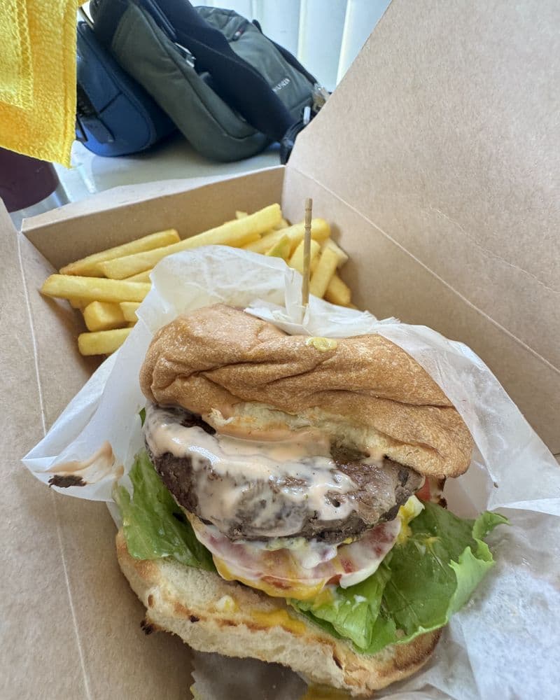 A burger in a soft wrap with a box of fries