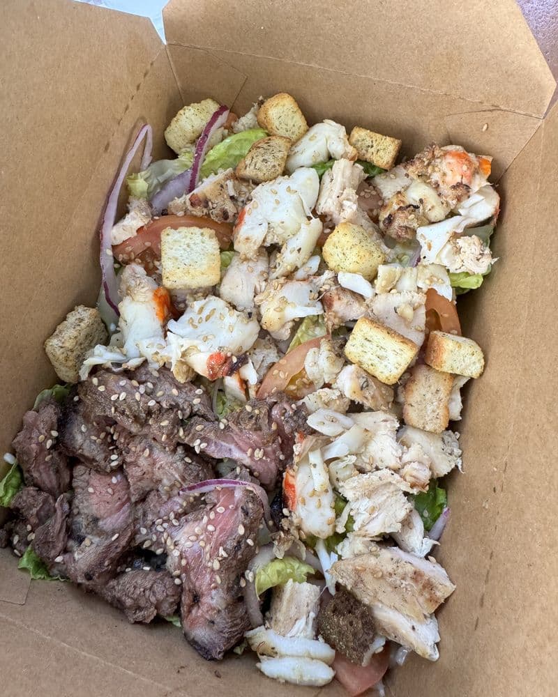 A chopped salad bowl with seafood, steak and croutons
