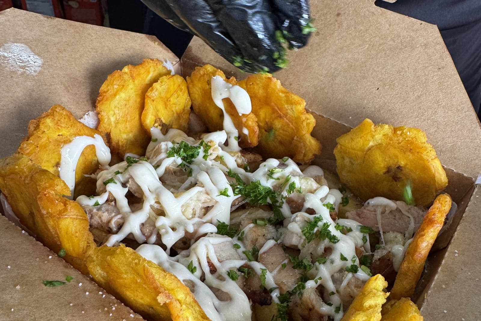Fried dough, saucy meat and slaw in a takeaway box